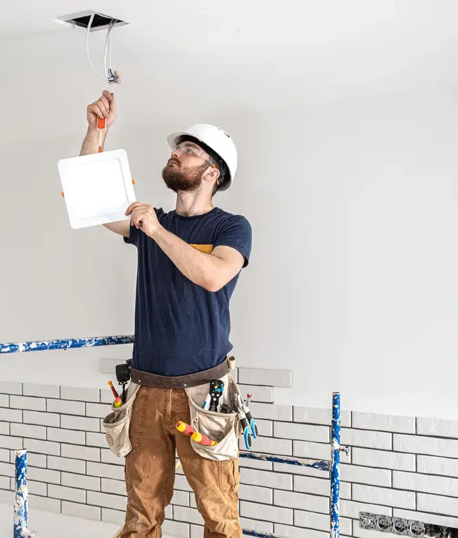 Professional Electrician installing light fixture